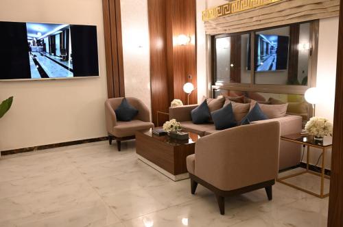 a living room with a couch and a tv at فندق امان - أحد رفيدة in Ahad Rafidah