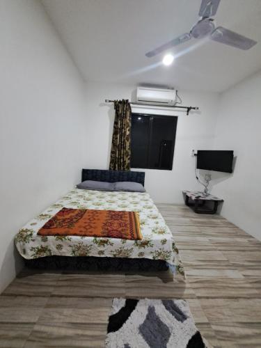 Un dormitorio con una cama y un televisor. en Nav's B&B, en Nadi