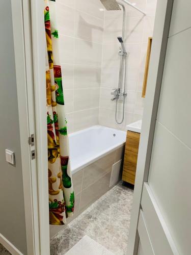 a bathroom with a shower and a tub and a sink at Толеби in Astana