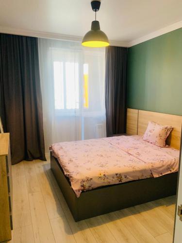 a bedroom with a bed and a green wall at Толеби in Astana