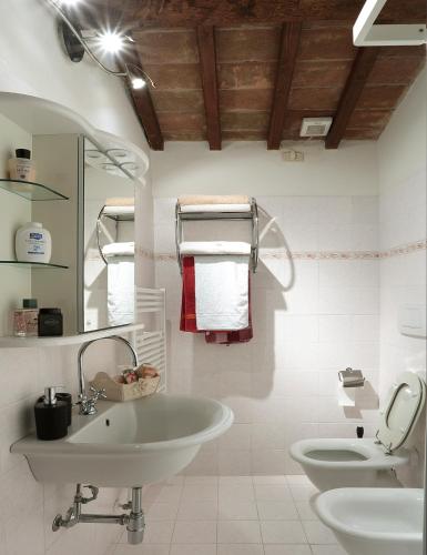 a white bathroom with a sink and a toilet at Azienda Agricola A Bonacchi in Montalcino
