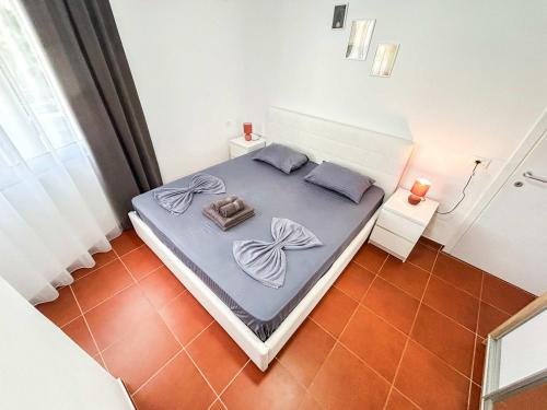 Dormitorio pequeño con cama con sábanas moradas en SeaShell, en Golemasi
