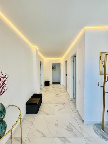 a hallway with white walls and a large tile floor at Vila Pombal Tomar - Luxury Apartment with private pool and Castle View in Tomar