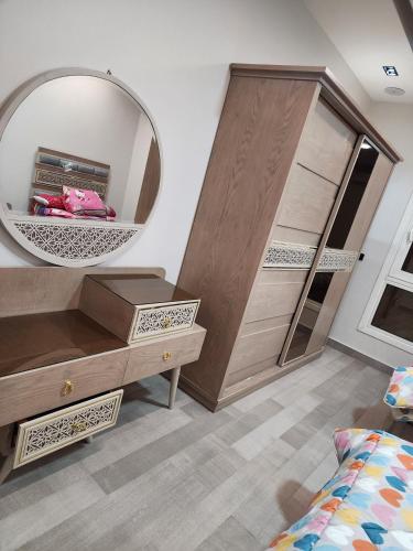 a bedroom with a mirror and a dresser and a bed at cozy flat in New Administrative Capital near European universities in Kafr ash Sharā‘inah