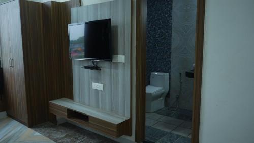 a bathroom with a television and a toilet at Hotel Holiday Fun Resort in Prāgpura