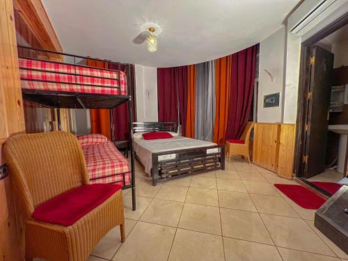a bedroom with a bunk bed and a chair at Senhaja Hôtel et Spa in Jenane Sidi Amer