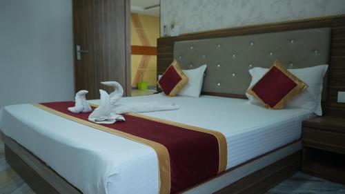 a bedroom with a large bed with white sheets and stuffed animals at Hotel Holiday Fun Resort in Prāgpura