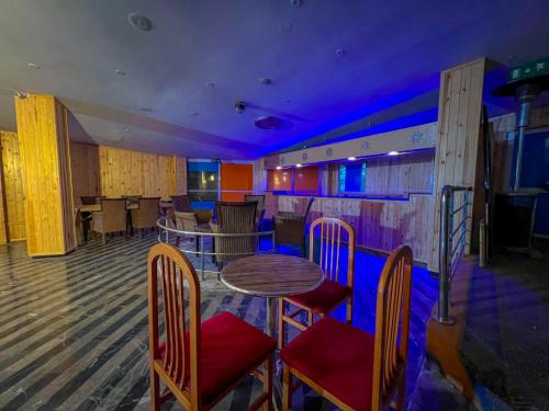 a bar with a table and chairs and purple lighting at Senhaja Hôtel et Spa in Jenane Sidi Amer