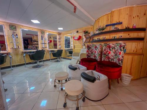 a salon with chairs and a couch and tables at Senhaja Hôtel et Spa in Jenane Sidi Amer