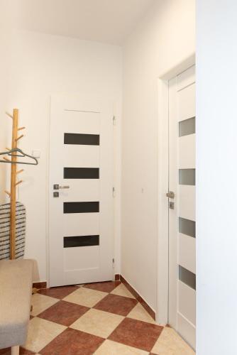 una habitación con una puerta blanca con rayas negras en Penzion U Radnice, byt 3, en Znojmo