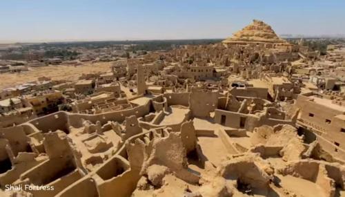 a view of the ruins of an ancient city with a pyramid at Siwa Oracle Hostel in Siwa