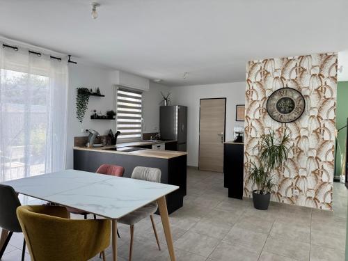 a kitchen and dining room with a table and chairs at Maison pour vos séjours en famille ou entre amis in Arthon-en-Retz