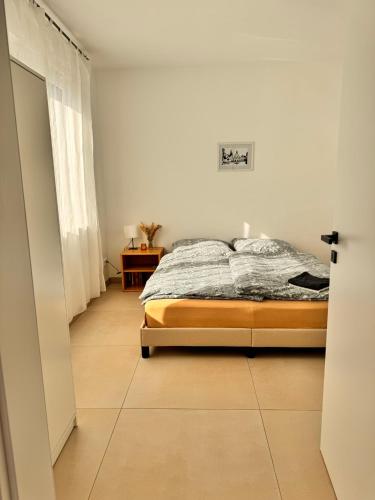a bedroom with a bed and a tiled floor at Heni Apartments in Gau-Algesheim