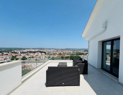 a balcony with a table and chairs on a building at Vila Pombal Tomar - Luxury Apartment with private pool and Castle View in Tomar
