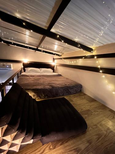 two beds in a room with lights on the ceiling at Munchies Bed & Breakfast in Bangkok