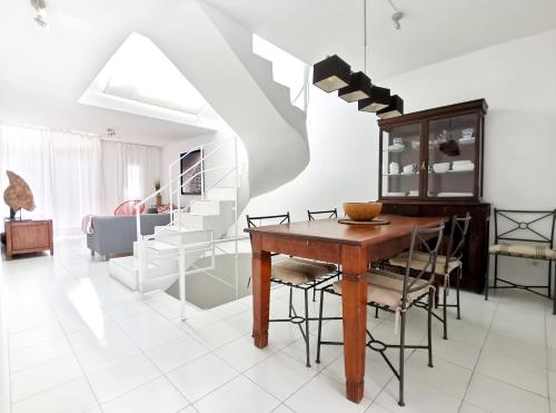 een eetkamer met een tafel en stoelen en een trap bij Sun & Beach 9 in Corralejo