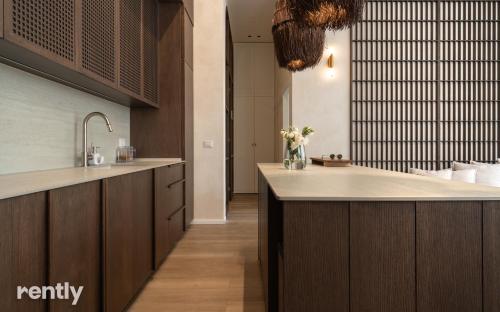 a kitchen with wooden cabinets and a counter top at Luxury Suites With Balcony And Jacuzzi At Sea Side By Rently in Eilat