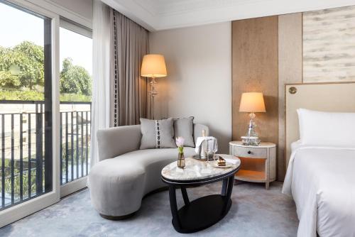 a hotel room with a bed and a couch and a table at Waldorf Astoria Jerusalem in Jerusalem
