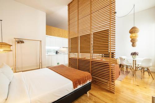 a bedroom with a bed and a wooden wall at Porto Ribeira Flat in Porto