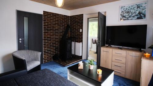 a living room with a tv and a fireplace at Chata se saunou přímo u lesa, nedaleko Hracholuské přehrady 
