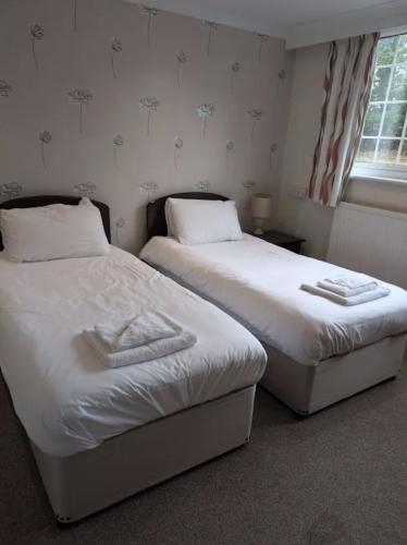 two beds sitting next to each other in a room at Northop Hall Country House Hotel in Mold