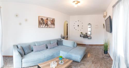 un soggiorno con un divano blu e un tavolo di 270° a Hydra