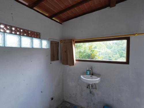 a bathroom with a sink and a window at Casa Matā Phitā Cottage in Patjung