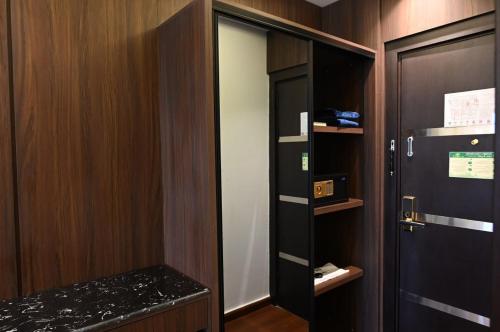 a walk in closet with a black door and wooden walls at فندق امان أبها - المحالة in Abha