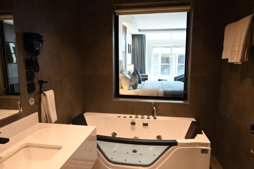 a bathroom with a tub and a sink and a mirror at فندق امان أبها - المحالة in Abha