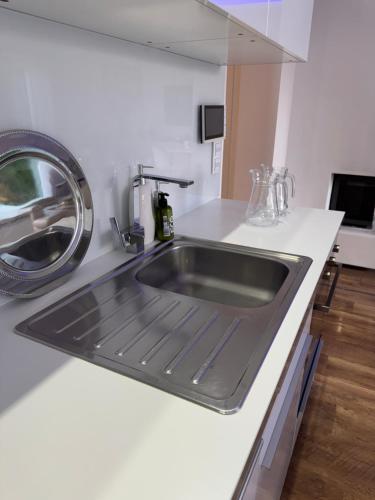 a kitchen with a sink in a white counter top at Vila Martina in Popůvky