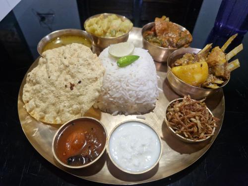 een bord eten met rijst en kommen eten bij Panchobon Art Resort in Shānti Niketan