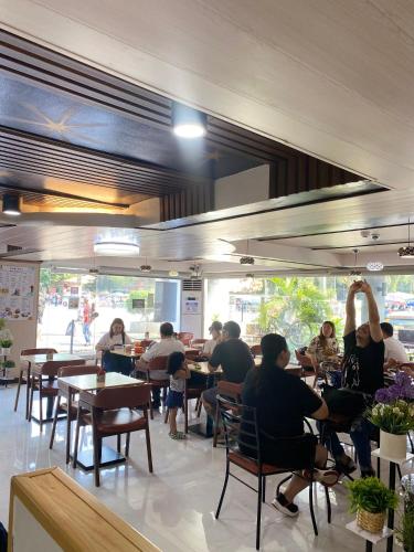 a group of people sitting at tables in a restaurant at Comfy Inn Manila-Kalaw in Manila