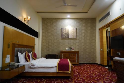 a hotel room with a bed and a television at The Grand Shekhawati in Rāmsir