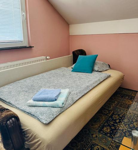 a bedroom with a bed with blue pillows on it at Apartman Feniks in Sjenica