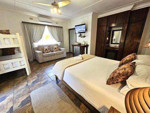 a bedroom with a large white bed and a couch at Leopard Corner Lodge in St Lucia