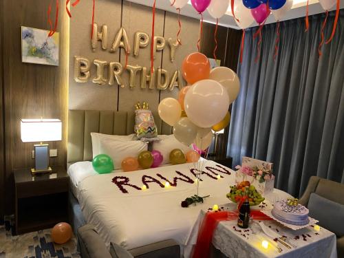 a room with a bed with balloons and a happy birthday sign at فندق امان أبها - المحالة in Abha