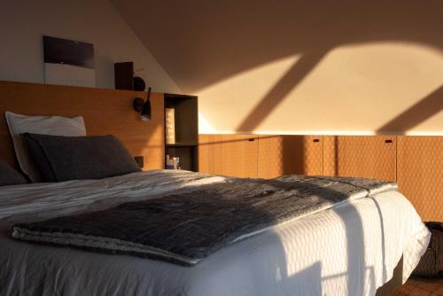 a bedroom with a bed with a shadow on the wall at Le Temps de Livresse in Namur