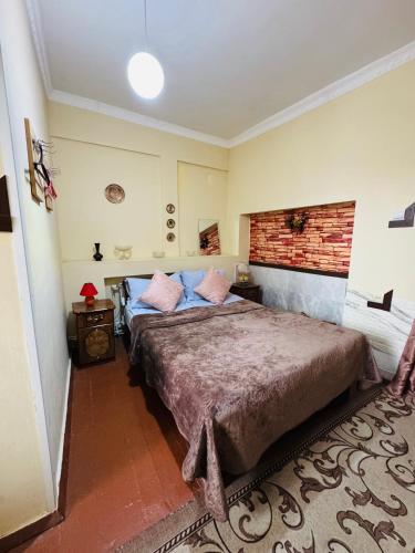 a bedroom with a large bed and a brick wall at Lovely Goris in Goris