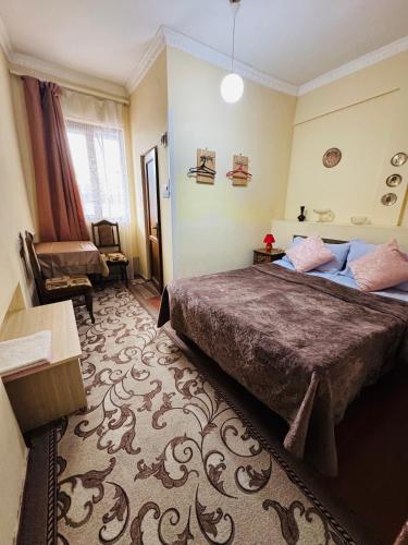 a hotel room with a bed and a chair at Lovely Goris in Goris