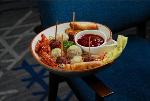 a bowl of food with meatballs and sauce on a table at Hotel Srijan in Vrindāvan