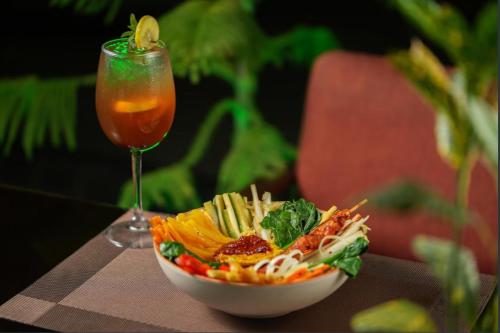 a bowl of pasta and a drink next to a salad at Hotel Srijan in Vrindāvan