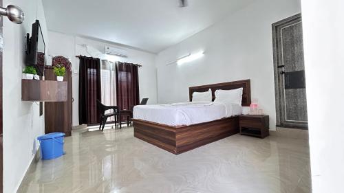 a bedroom with a bed and a table and chairs at Sunshine Guest House in Calangute