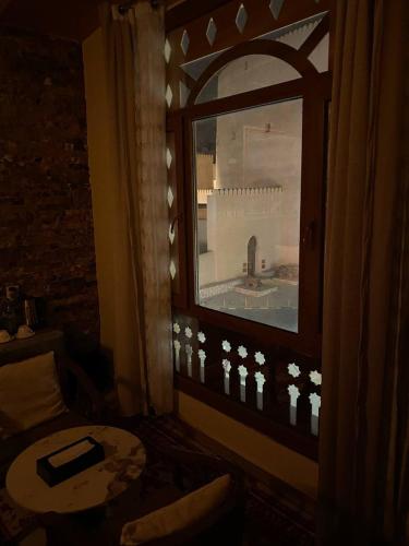 a room with a window with a view of a building at Durrat Nizwa Inn in Nizwa