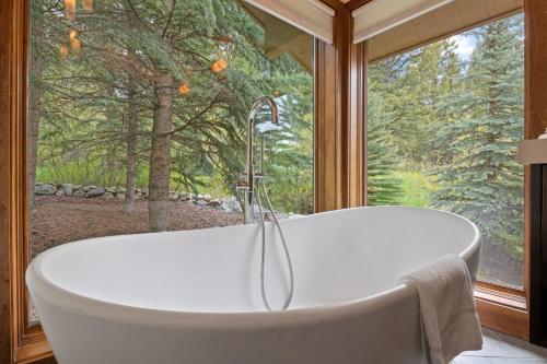 a bath tub in a room with a large window at RMR: Wildflower House in Teton Village in Teton Village