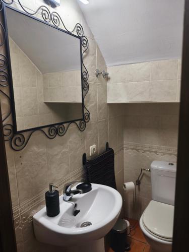 a bathroom with a sink and a mirror and a toilet at Casa Ani Islantilla in Islantilla