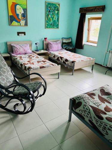 a room with three beds and a chair and a window at Lovely Goris in Goris