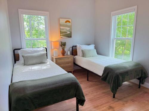 two beds in a room with two windows at Stylish Lake Getaway: Kayaks •Foosball •Ping Pong in Badin