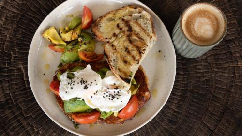 une assiette de nourriture avec un sandwich et une tasse de café dans l'établissement Mambo Villas, à Kuta Lombok