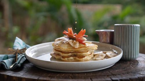 une assiette avec une pile de crêpes sur une table dans l'établissement Mambo Villas, à Kuta Lombok