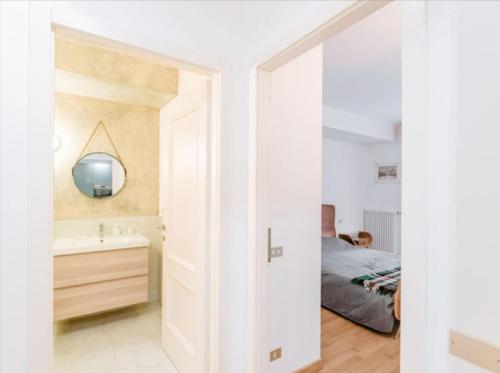 a bedroom with a bed and a sink and a mirror at LA CALETTA SUITE APARTMENT- Panoramic Pool & Box Auto in Blevio